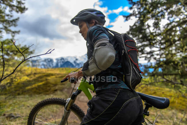 Bicicleta de montaña mujer en un bosque en las montañas canadienses - foto de stock