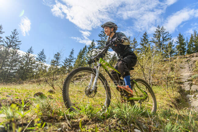 Donna mountain bike in una foresta nelle montagne canadesi in B — Foto stock