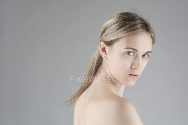 Nudo giovane donna su sfondo grigio — Foto stock