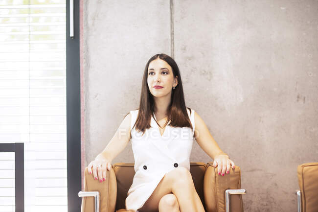 Geschäftsfrau sitzt im Sessel und lächelt — Stockfoto