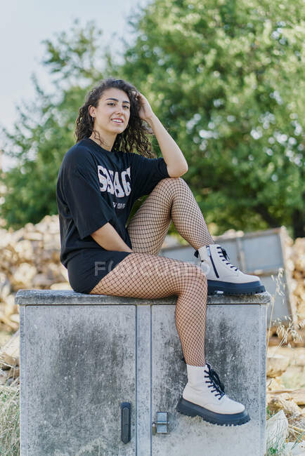 Jovem mulher sentada no antigo armário ao ar livre — Fotografia de Stock