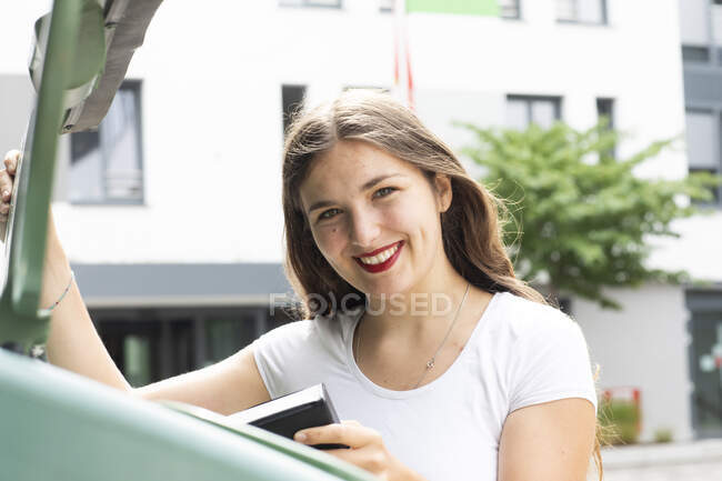 Mujer joven usando papelera de reciclaje - foto de stock