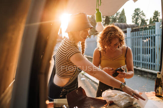 Junge Frauen am Heck ihres Lieferwagens — Stockfoto