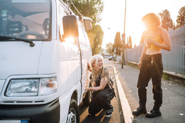 Young female couple working on van and having a beer — Stock Photo