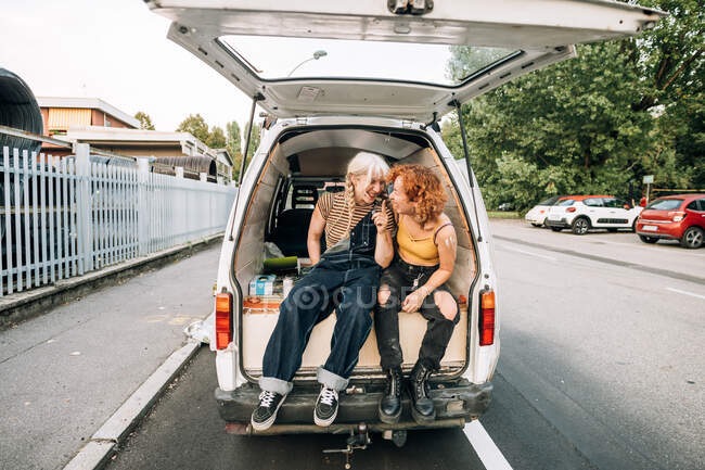 Счастливая лесбийская пара сидит на заднем сиденье фургона — стоковое фото