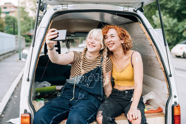 Couple lesbien souriant et prenant selfie — Photo de stock