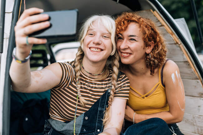 Coppia lesbica sorridente e prendendo selfie — Foto stock