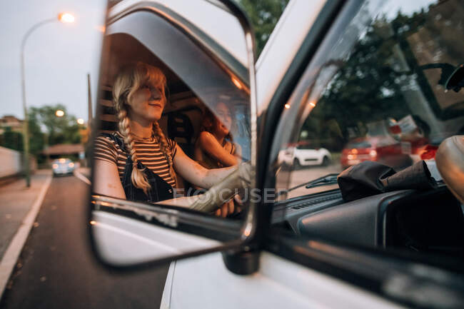 Vista en espejo de mujeres jóvenes conduciendo furgoneta - foto de stock
