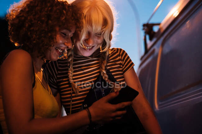 Female couple looking at phone together — Stock Photo