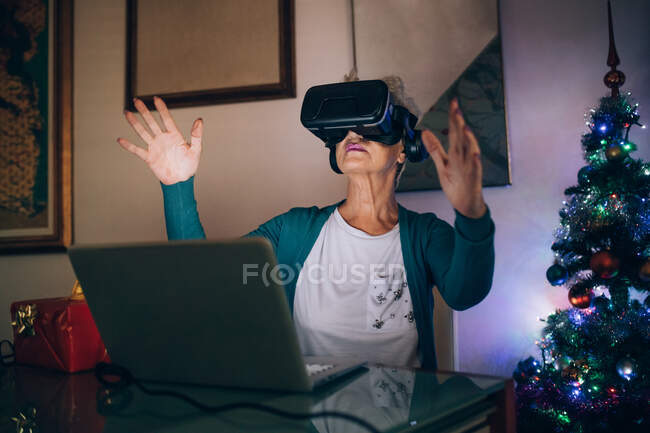 Femme utilisant casque de réalité virtuelle à la maison — Photo de stock