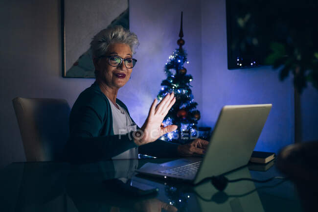 Femme agitant sur appel vidéo, arbre de Noël en arrière-plan — Photo de stock