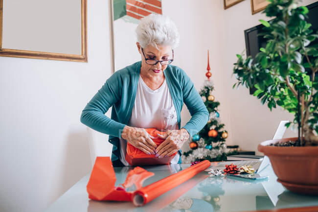 Woman wrapping Christmas presents — Stock Photo