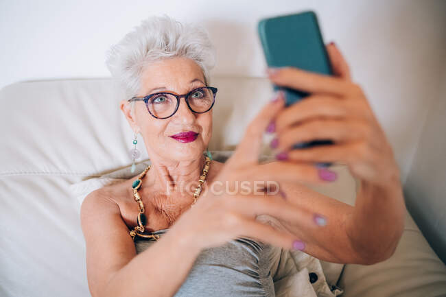 Mujer teniendo videollamada en su teléfono - foto de stock