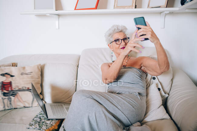 Mujer que tiene videollamada en su casa - foto de stock