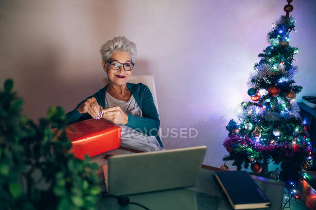 Frau auf Videoanruf mit Weihnachtsgeschenk — Stockfoto