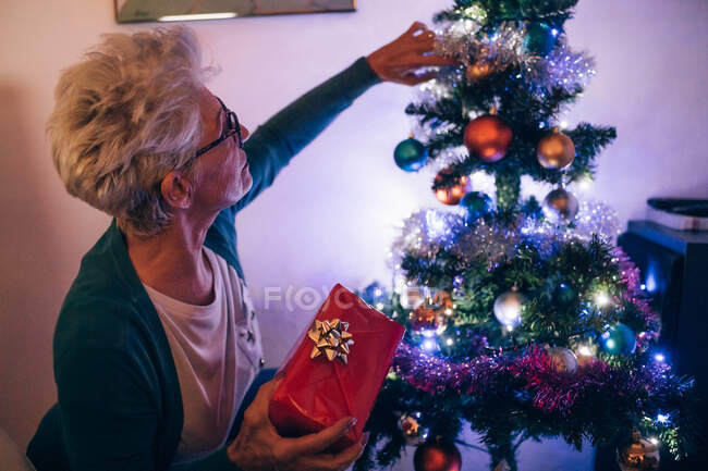 Woman decorating Christmas tree — Stock Photo