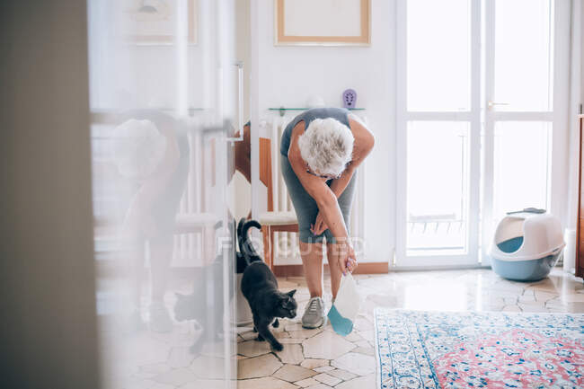 Mulher sênior em casa com gato de estimação — Fotografia de Stock
