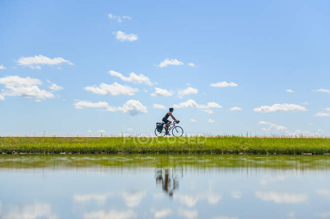 Cyclist riding past water, Ontario, Canada — Stock Photo