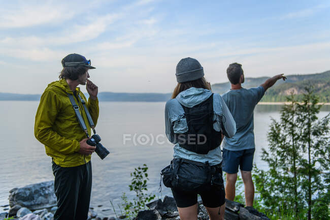 Senderistas mirando sobre el agua, Ontario, Canadá - foto de stock