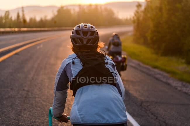 Ciclistas en carretera al atardecer, Ontario, Canadá - foto de stock