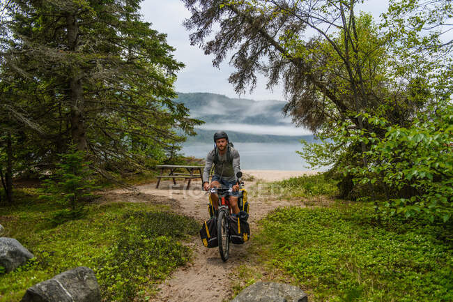Велосипедист с велосипедом на живописной остановке в путешествиях, Онтарио, Канада — стоковое фото