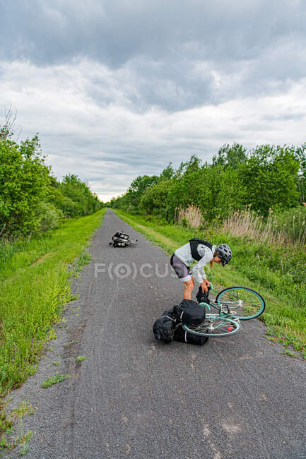 Cyclist picking up bike from road, Ontario, Canada — Stock Photo