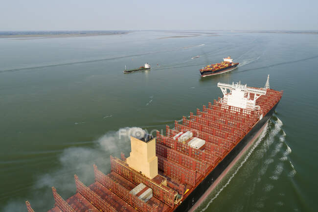 Ein 400m langes Containerschiff fährt in den Hafen von Antwerpen ein und passiert — Stockfoto