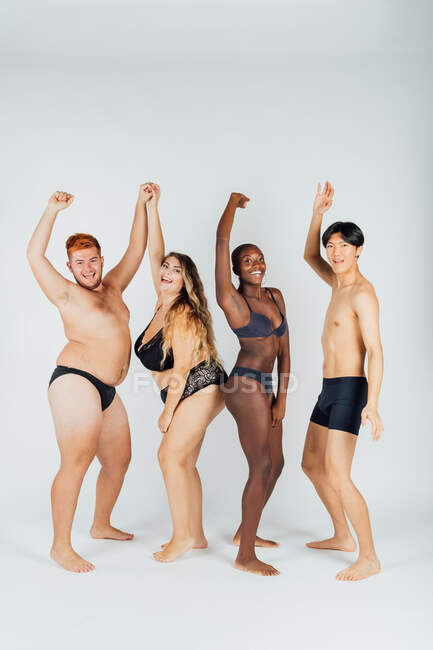 Group of young people wearing underwear, arms raised — Stock Photo