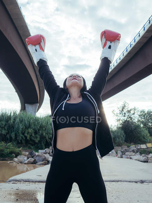 Boxer outdoors with arms raised — Stock Photo
