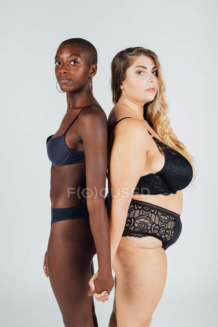 Female couple, standing back to back in underwear — Stock Photo