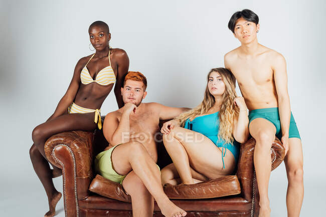 Портрет молодых людей на диване в купальниках и нижнем белье — стоковое фото