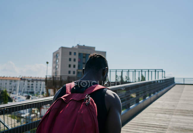 Junger Mann läuft über Brücke — Stockfoto
