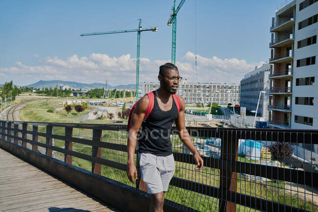 Jeune homme marchant sur le pont — Photo de stock