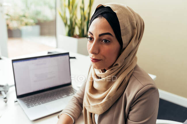 Businesswoman in office with laptop — Stock Photo
