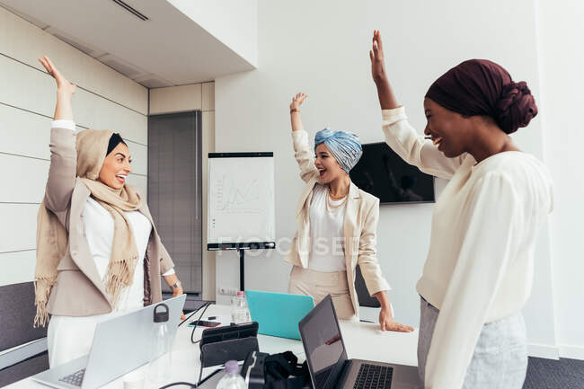 Businesswomen raising arms together — Stock Photo