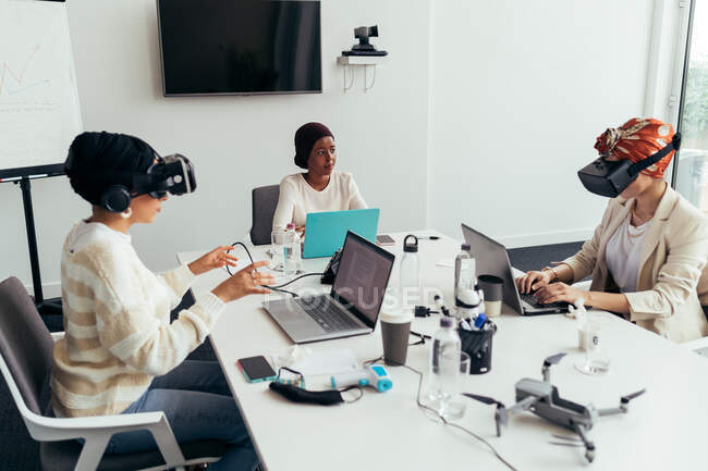 Коллеги, использующие гарнитуры виртуальной реальности в офисе — стоковое фото