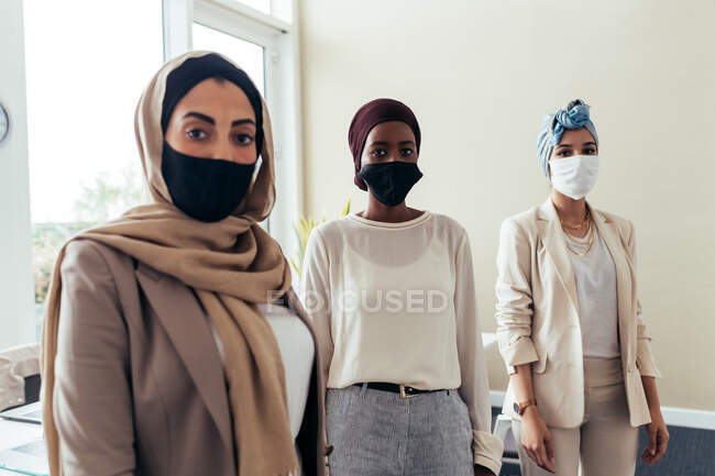 Бізнес-леді в масках для обличчя в офісі — стокове фото