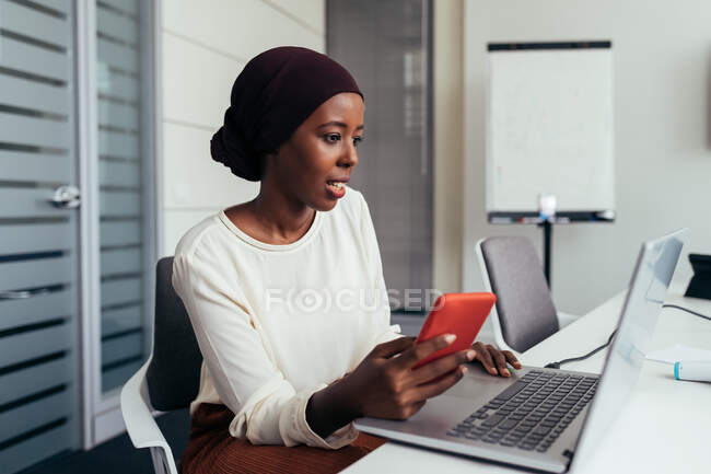 Деловая женщина с помощью смартфона и ноутбука — стоковое фото