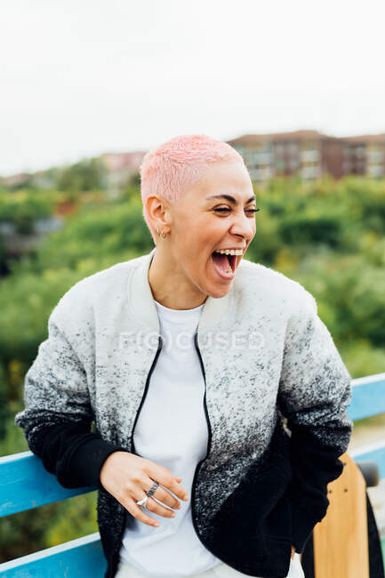 Молодая женщина смеется в городе — стоковое фото