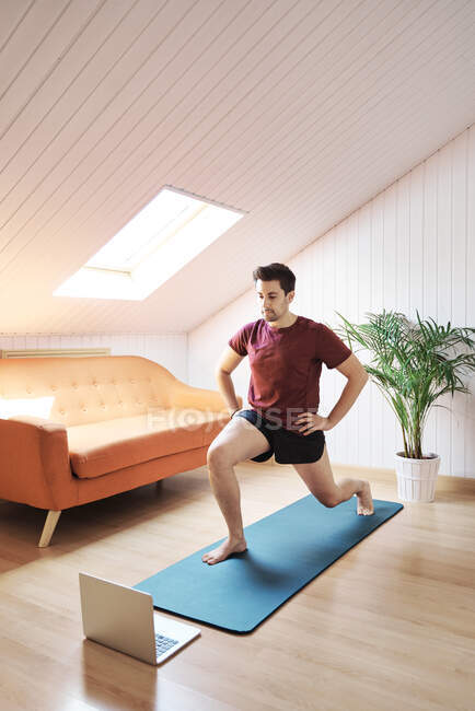 Man following online exercise class at home — Stock Photo