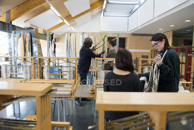 Profesor y estudiantes en taller de textiles - foto de stock