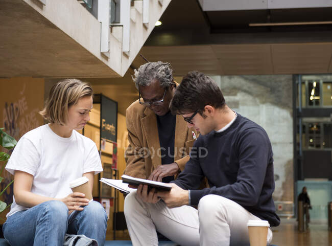 Lecturer and students discussing notes — Stock Photo