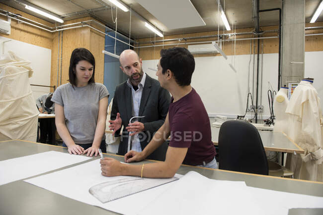 Lecturer talking to fashion students — Stock Photo