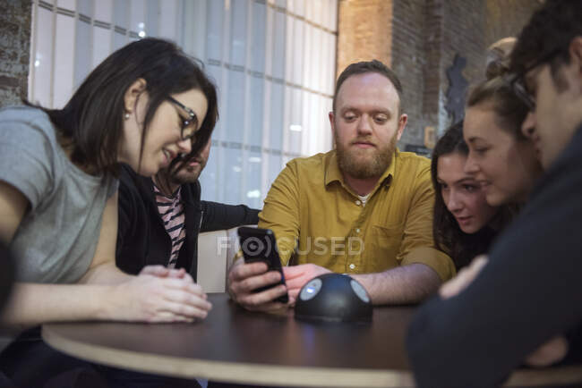 Schüler schauen gemeinsam aufs Smartphone — Stockfoto