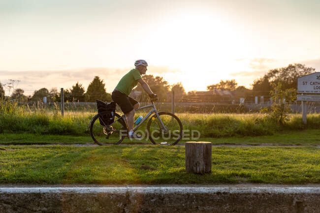 Man cycling along canal path — Stock Photo
