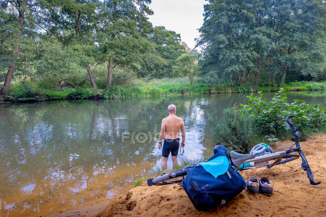 Swimmer at edge of river, bicycle in foreground — Stock Photo