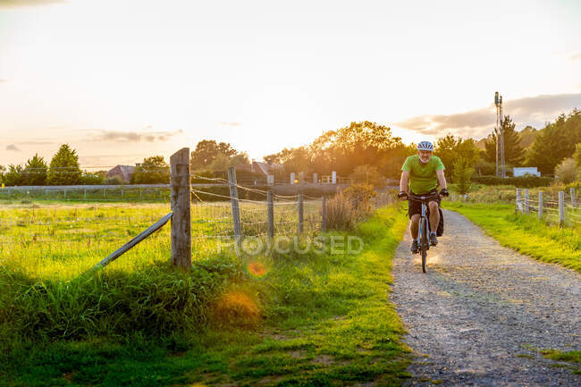 Mann mit Mountainbike auf Landweg unterwegs — Stockfoto