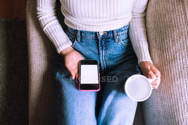 Cropped view, woman with phone and hot drink — Stock Photo