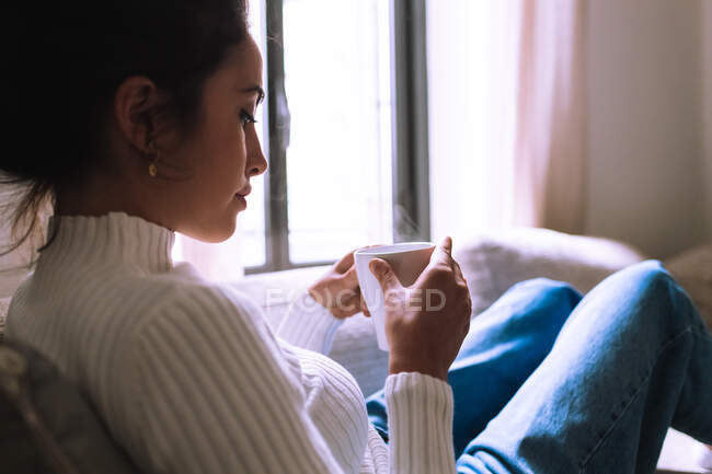 Mujer joven tomando un descanso con una bebida caliente - foto de stock