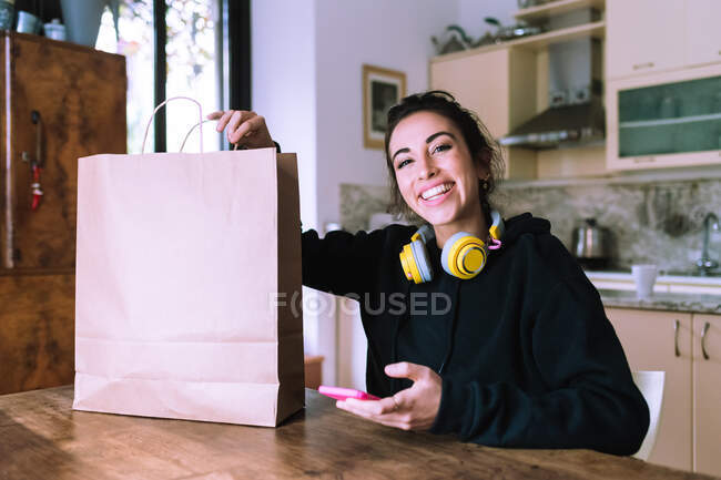 Mujer joven con compra en bolsa de papel marrón - foto de stock